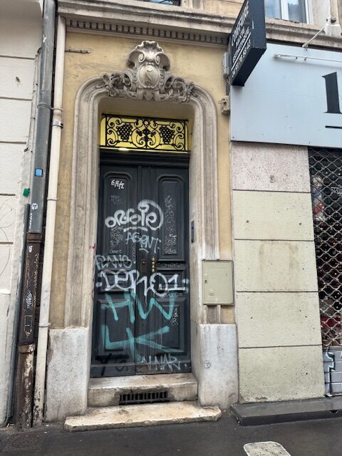 Porte ancienne taguée avant travaux à Marseille