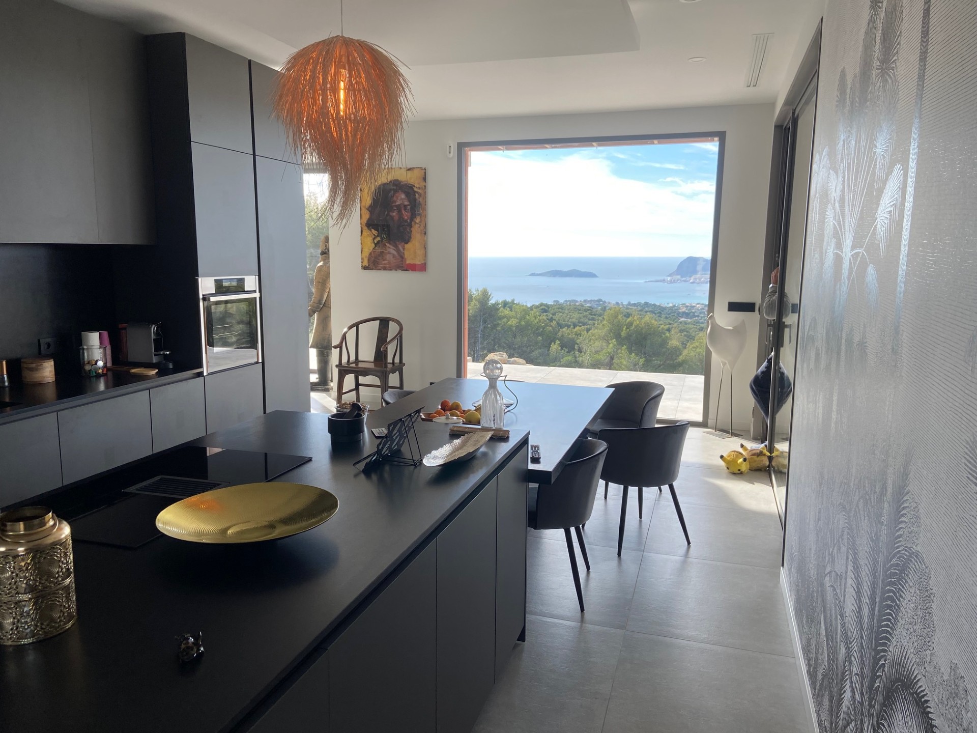 Cuisine ouverte avec grande baie vitrée vue Méditerranée